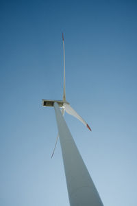 Low angle view of windmill against clear blue sky