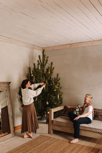 A man and a woman in love embrace give gift gifts celebrate a holiday at the christmas tree at home