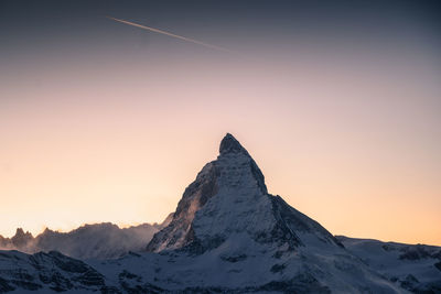 Scenic view of snowcapped mountain against sky during sunset