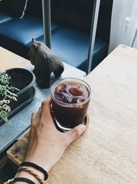 Midsection of person holding coffee cup on table