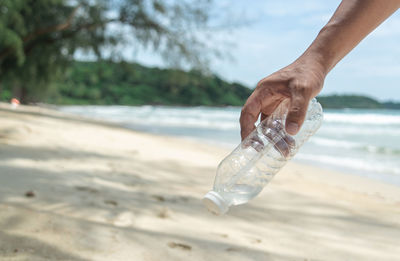 Cropped hand holding bottle