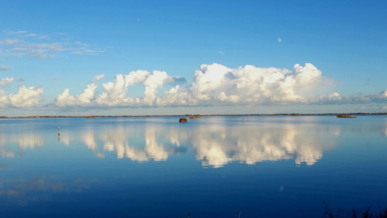 water, tranquil scene, tranquility, waterfront, scenics, reflection, sky, beauty in nature, blue, lake, sea, nature, idyllic, calm, cloud - sky, cloud, outdoors, no people, non-urban scene, remote