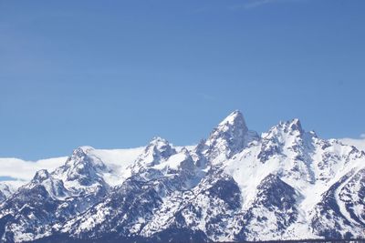 Scenic view of snowcapped mountains against clear blue sky