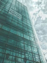 Low angle view of modern building against cloudy sky