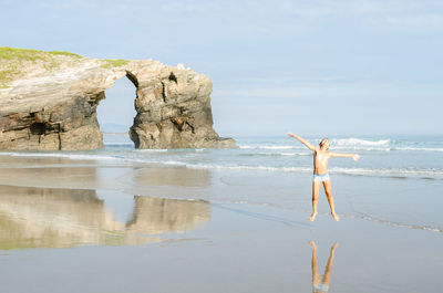 Man standing on beach against sky