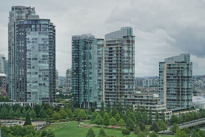 Buildings in city against cloudy sky