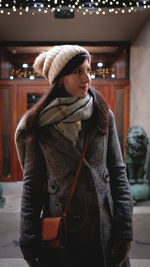 Young woman standing outdoors at night during winter