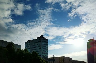 Low angle view of modern building against cloudy sky