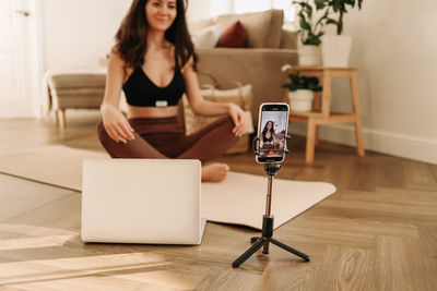 Woman training and exercise online at home. a blogger records videos in workout using a smartphone