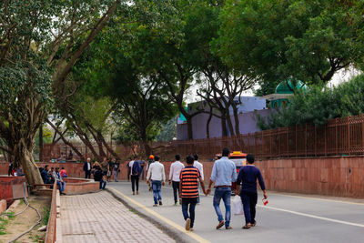 Rear view of people walking on footpath