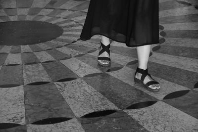 Low section of woman walking on road