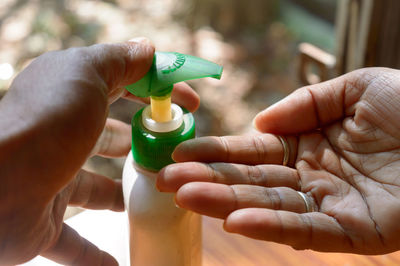 Close-up of hand holding plastic bottle