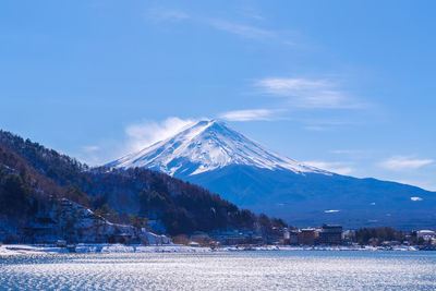 Scenic view of snowcapped mountains against blue sky