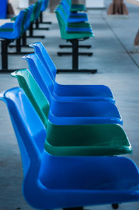 Close-up of blue chairs on table