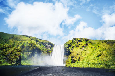 Scenic view of waterfall against sky