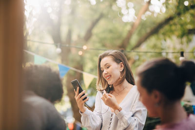 Portrait of woman using mobile phone outdoors