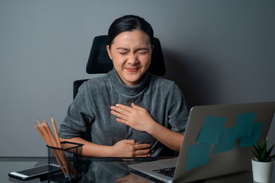 Young man using mobile phone while sitting on table