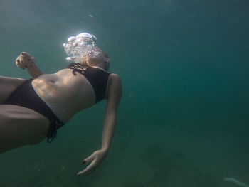 Portrait of young woman swimming in sea