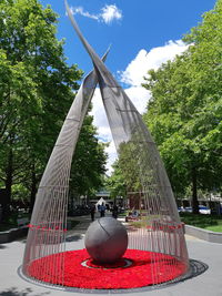 Sculpture in park against sky in city