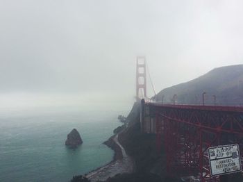 View of suspension bridge against cloudy sky