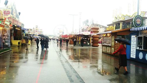 People walking on sidewalk during rainy season