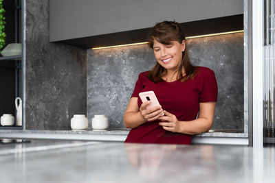 Portrait of a smiling young woman using mobile phone