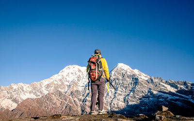 Man standing on mountain against blue sky