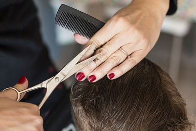 Midsection of woman cutting man hair