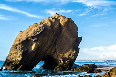 Rock formation in sea against sky