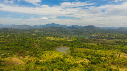 Aerial drone of valley with agricultural land surrounded by forest. sri lanka.