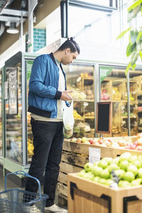 Man buying fruits in organic supermarket