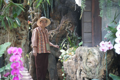 Asian old elderly elder woman resting relaxing in rose flower garden. senior leisure lifestyle