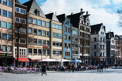 People on street in city by buildings