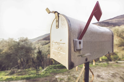 Metal mail box with typical american style, behind you see a countryside landscape