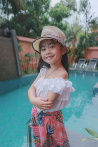 Fashion portrait of little girl with hat in pool