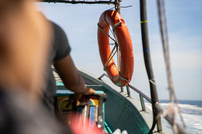 Cropped image of man standing on fishing boat in sea