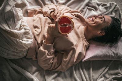 High angle view of woman lying on bed at home