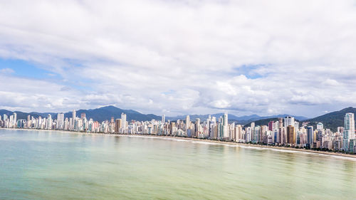 View of city by sea against sky