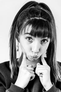 Close-up portrait of girl with bangs against white background