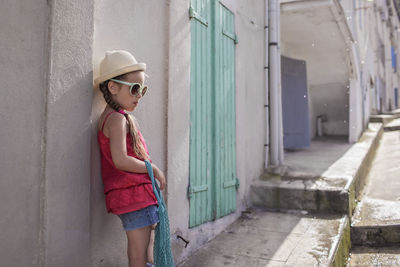 Portrait of woman standing against wall