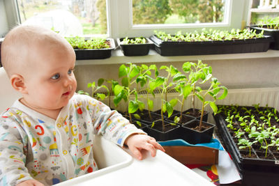 Cute baby sitting in plant nursery