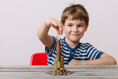 Portrait of happy boy playing with ball on table