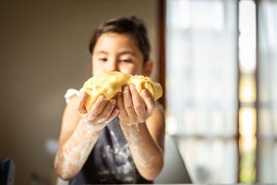 Close up of child hands dirty with flour holding the dough