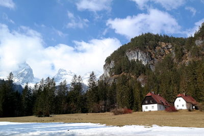 Scenic view of snow covered trees and houses against sky