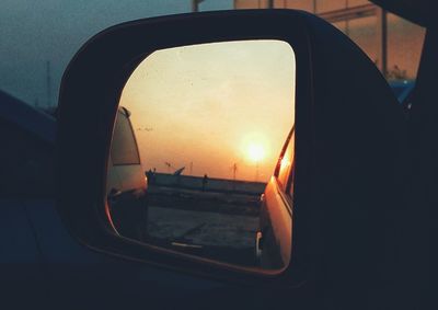 Reflection of sky on side-view mirror at sunset