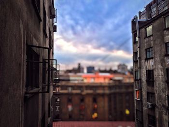 Buildings against cloudy sky