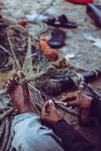 Close-up of man making fishing net