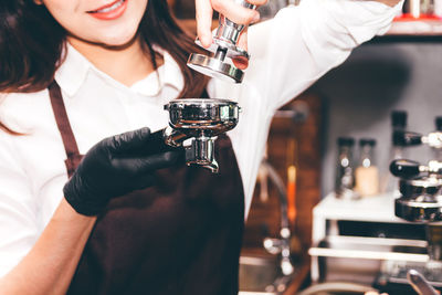 Midsection of woman holding drink at bar