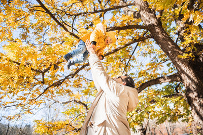 Low angle view of woman standing on tree