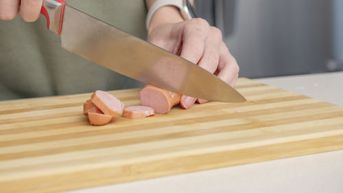 Midsection of woman holding knife on table